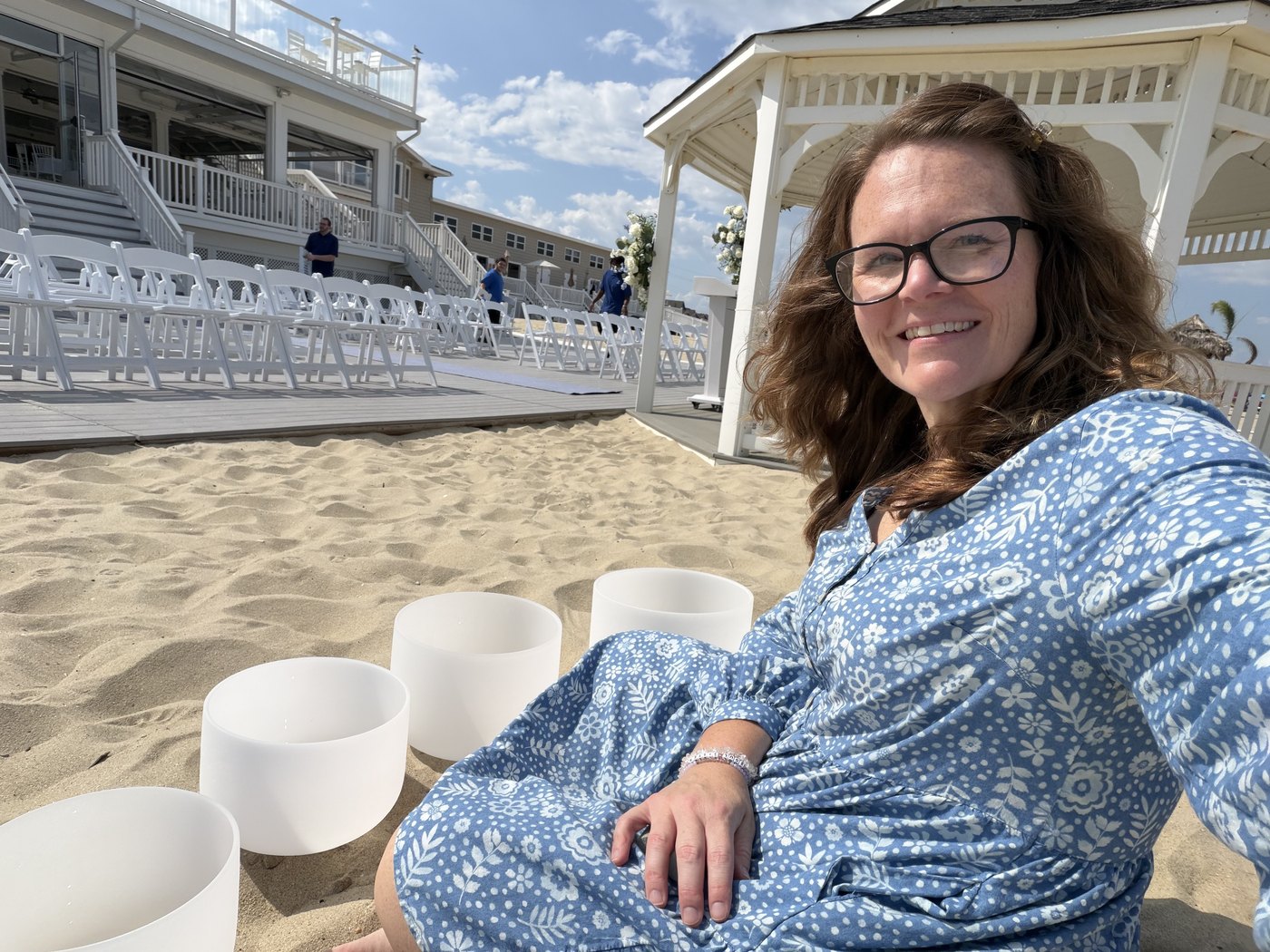 Crystal singing bowls set up on the sand for a beachside sound bath